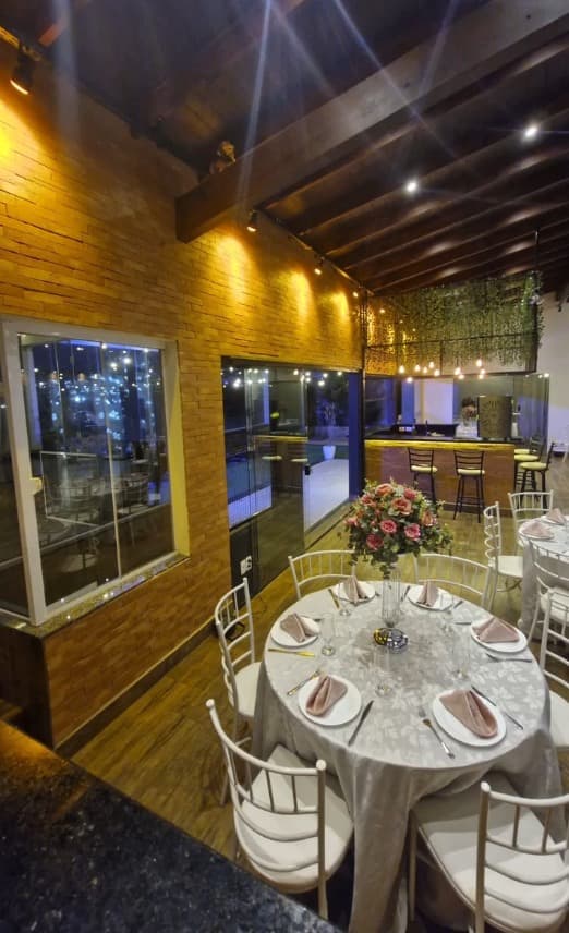 Mesa montada com vista para o bar e parede de pedra